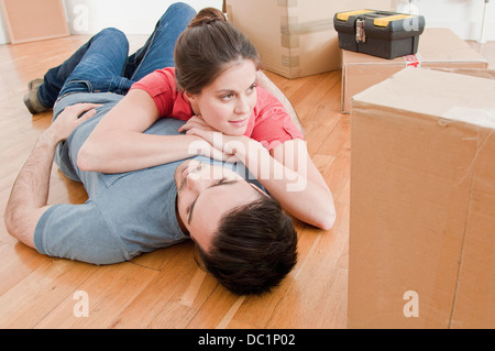Young couple taking a break amongst cardboard boxes Stock Photo