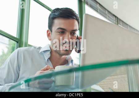 Young male office worker talking on mobile phone Stock Photo