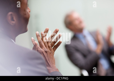 Businessmen clapping in meeting Stock Photo