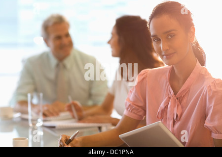 Portrait of confident businesswoman with digital tablet in meeting Stock Photo