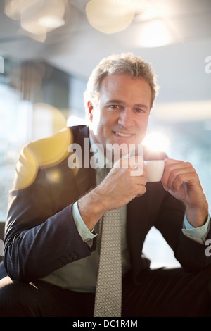 Portrait of smiling businessman drinking espresso Stock Photo