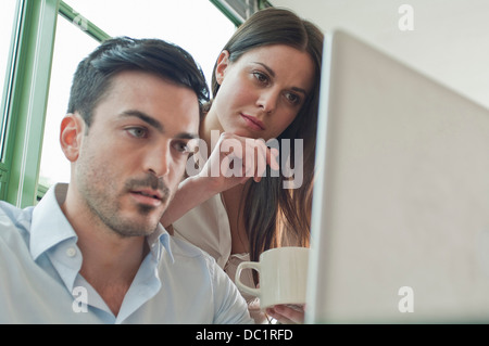 Young office workers looking at laptop Stock Photo
