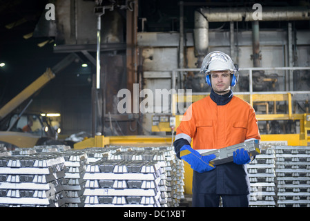 Portrait of warehouse worker holding aluminum ingot