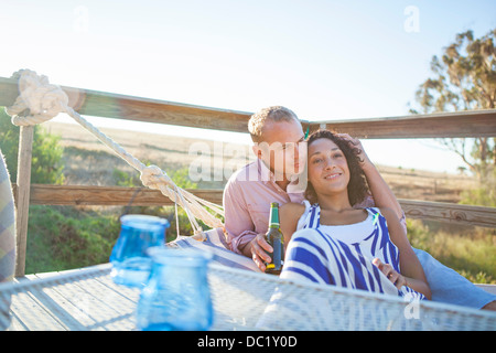 Young couple relaxing on hammock on balcony Stock Photo