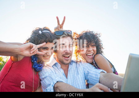 Young man and women making gestures at digital tablet Stock Photo