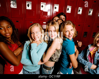 Young friends standing together in school locker room, portrait Stock Photo