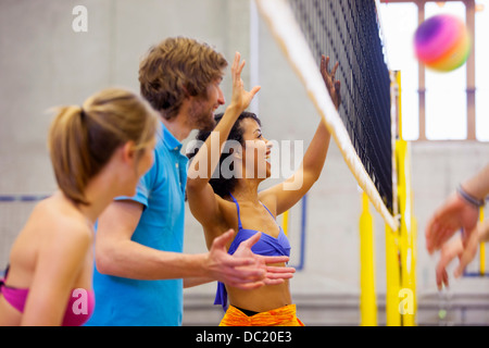 Friends enjoying indoor beach volleyball Stock Photo