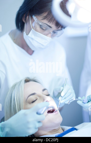 Female dentist examining patients teeth Stock Photo