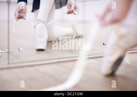 Ballerina putting on ballet slippers Stock Photo