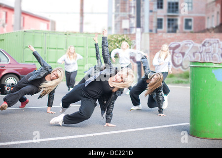 Girls practicing dance moves in carpark Stock Photo