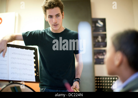 Young male teaching boy how to play drums Stock Photo