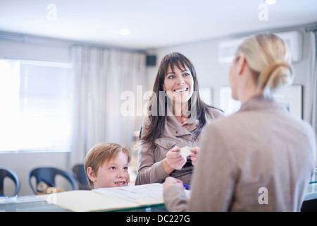 Mother and son making appointment at hospital reception Stock Photo