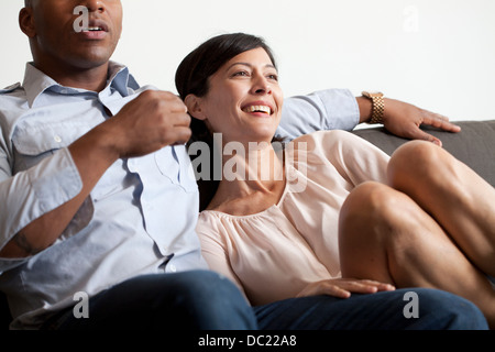 Couple relaxing on sofa, smiling