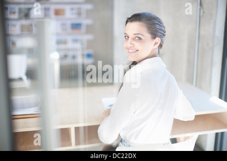 Young woman at desk in creative office Stock Photo
