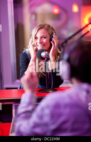 Young man and woman broadcasting in recording studio Stock Photo