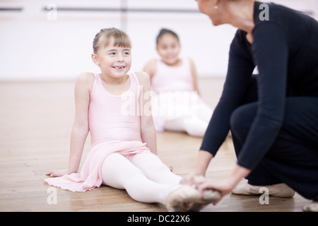 Teacher adjusting feet position of young ballerina Stock Photo