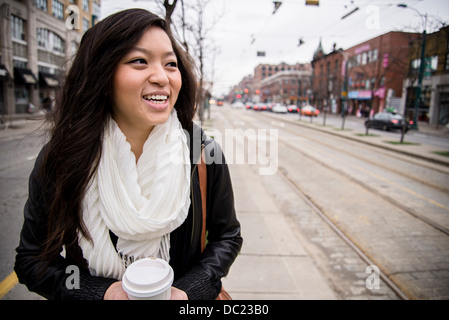 Young woman walking on street in city, smiling