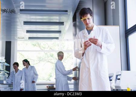 Chemistry student looking at chemical in laboratory Stock Photo