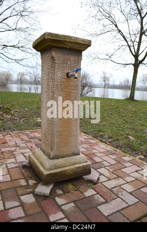 Brown Antique Stone Well with Tap Stock Photo