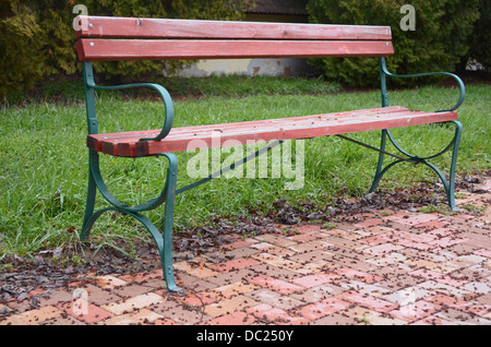 Iron and Wood Park Bench at the Edge of Sidewalk Horizontal Stock Photo