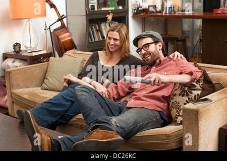 Couple sitting on sofa watching television Stock Photo