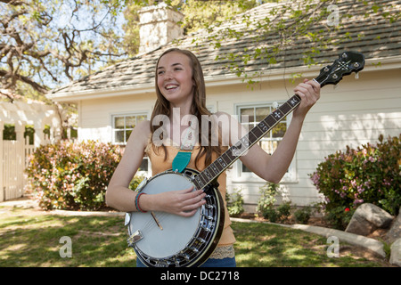 Teenage girl playing banjo Stock Photo