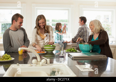 Three generation family in kitchen preparing food Stock Photo