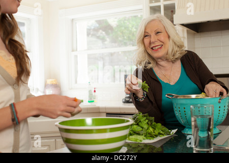 Granddaughter with grandmother preparing salad Stock Photo