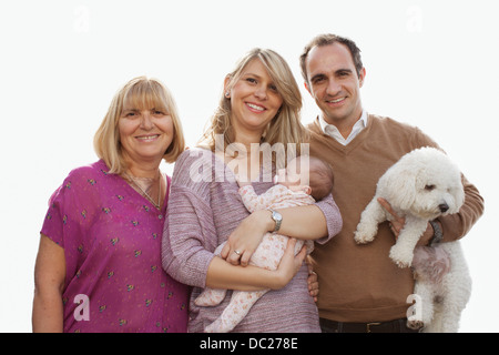 Portrait of three generation family with newborn baby girl and dog Stock Photo