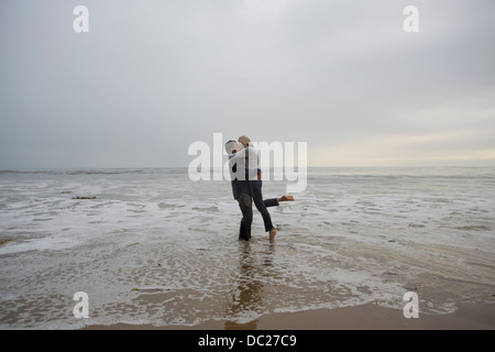 Mature couple embracing on beach Stock Photo