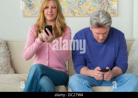 Mature couple using cell phones Stock Photo