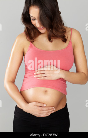 Pregnant woman touching stomach Stock Photo