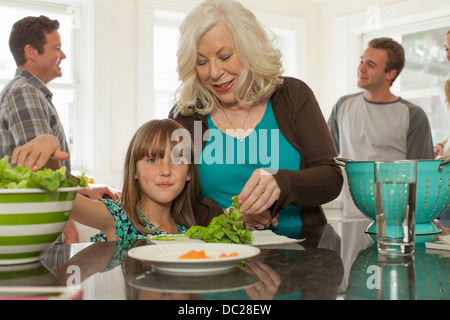 Granddaughter and grandmother preparing salad Stock Photo