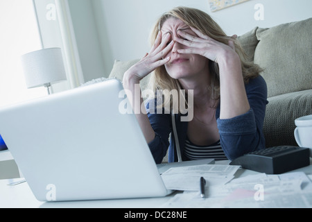 Stressed young woman rubbing eyes Stock Photo