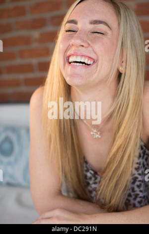 Portrait of young woman with long blonde hair laughing Stock Photo