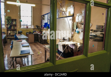 Broken glass window pane in school room door Stock Photo