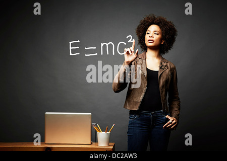 Woman solving mathematical equation Stock Photo