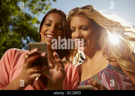 Women sharing text messages on phone Stock Photo
