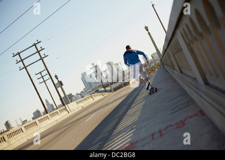 Man skateboarding on pedestrian walkway Stock Photo