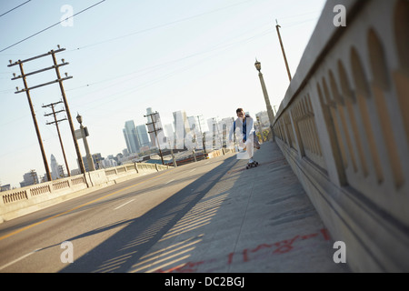 Man skateboarding on pedestrian walkway Stock Photo