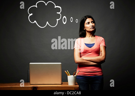 Woman with arms crossed day dreaming Stock Photo