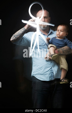 Man drawing to entertain baby in arms Stock Photo