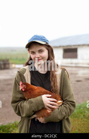 Girl carrying hen Stock Photo