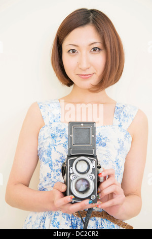 Smiling woman holding a 1960's classic camera Stock Photo