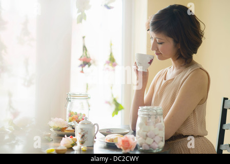 Woman looking down at tea cup Stock Photo