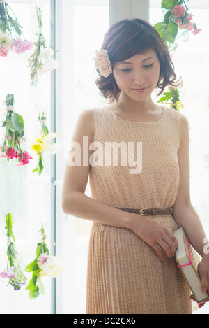 https://l450v.alamy.com/450v/dc2cx6/woman-in-front-of-glass-door-with-dangling-flowers-dc2cx6.jpg