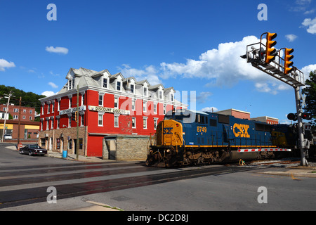 CSX diesel train number 8749 on former Baltimore and Ohio Railroad passing discount liquor store, Cumberland, Maryland , USA Stock Photo