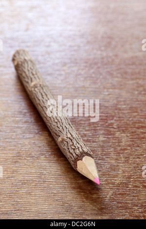 Tree trunk pencil on wooden table Stock Photo