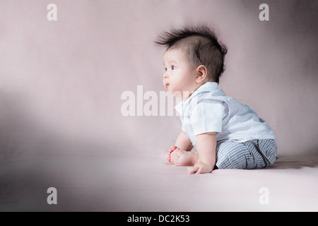 One image from a series of studio photos of a cute mixed race Asian Caucasian baby with wild hair making gorgeous expressions Stock Photo