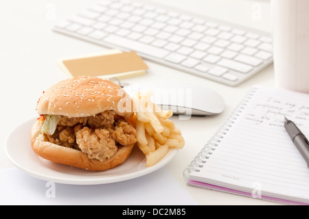 Fast food and other office items on desk Stock Photo